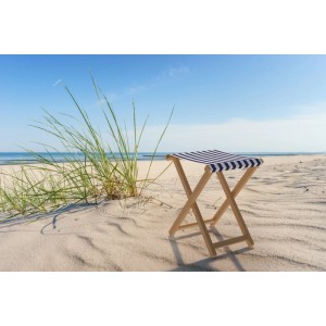 Klappbarer Gartenstuhl aus Buche mit blau-weiß gestreiftem Stoff auf Sandstrand. Für Garten & Outdoor.