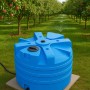 Blauer KMND 5000L Trinkwasser Wassertank im Obstgarten mit Bewässerung. Ideal für Garten & Regenwassernutzung.