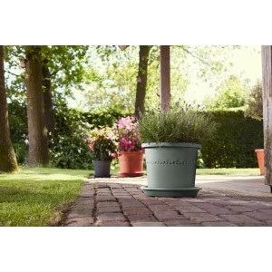 Grüner Elho Universal-Untersetzer (Ø 25 cm) unter Pflanztopf im Garten.
