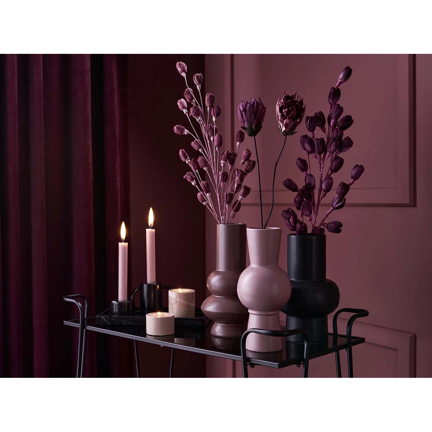 Dekorative Trockenblumen Lilie Midnight Mystery in Lila-Schwarz in Vasen auf einem Tisch.