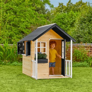Zwerkules Spielhaus Holli aus Holz mit Veranda, Fensterläden und Kind im Eingang.