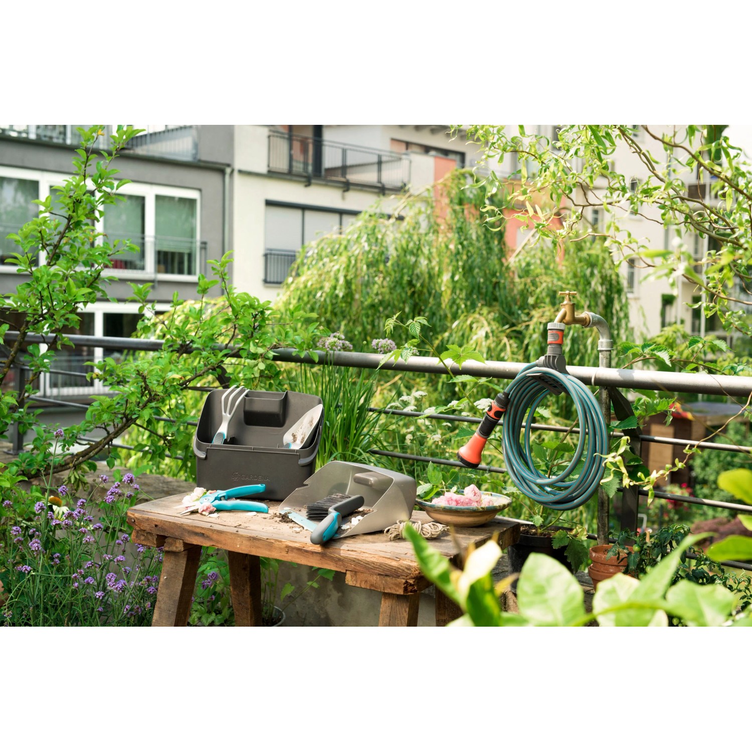 Gardena Terrassen-Spiralschlauch 7,5 m mit Gartengeräten und Zubehör auf einem Balkon.