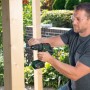 Mann bohrt mit Bosch 18V Akku-Bohrschrauber AdvancedDrill 18 V-80 ein Loch in ein Holzbrett.