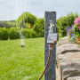 Gardena Bewässerungscomputer Select am Wasserhahn mit Rasensprenger im Garten.