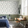 ESTAhome Tapete mit Vintage Dinosaurier-Muster in Blau und Grün an Kinderzimmerwand.