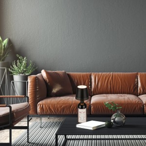 Brilo Akku-Flaschenlicht Flaska, schwarz, als Tischleuchte auf Weinflasche im Wohnzimmer.