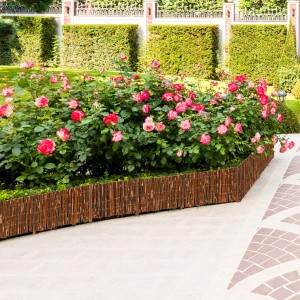 Flexible Weide Beeteinfassung (300x30cm) im Garten mit Rosenbeet als Dekoration.