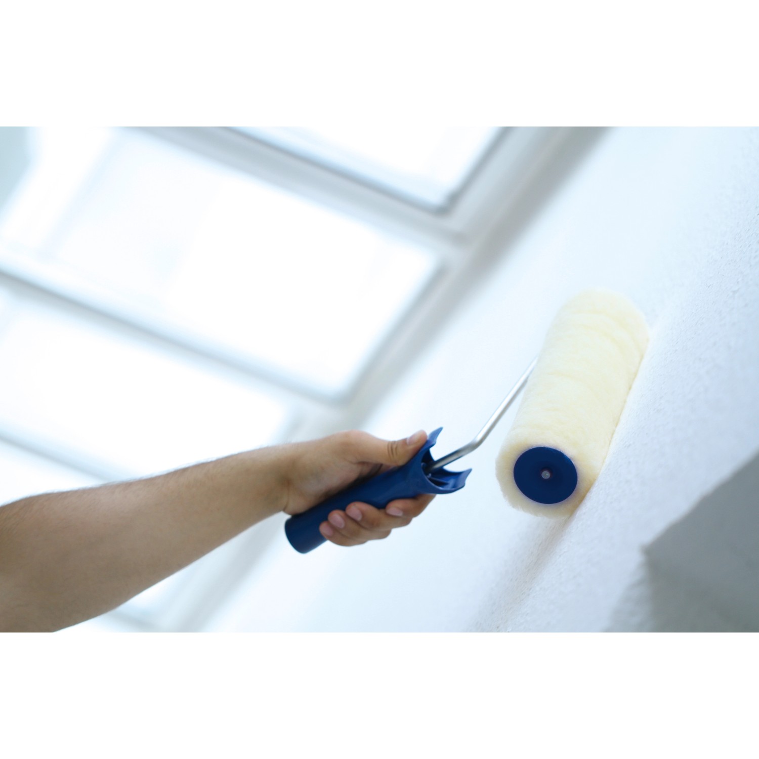 Hand streicht Wand mit LUX Vestanwalze 18 cm. Farbwalze für Dispersionsfarbe.