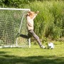 Junge schießt Ball vor Exit Fußballtor Scala Aluminium 180x120 cm Weiß im Garten.