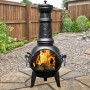 Buschbeck Mexiko-Ofen Leaf 136: Schwarze Feuerschale mit Grillfunktion und Blattmuster im Garten.