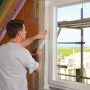 Anwendung von Siga Fentrim 20 Klebeband am Fensterrahmen für luftdichte Dämmung.