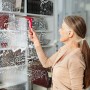 Frau benutzt Vileda Profi-Abzieher mit rotem Griff zur Fensterreinigung.