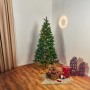 Grüne Kunsttanne Tramso mit LED-Beleuchtung, 185 cm hoch, im weihnachtlich dekorierten Wohnzimmer.