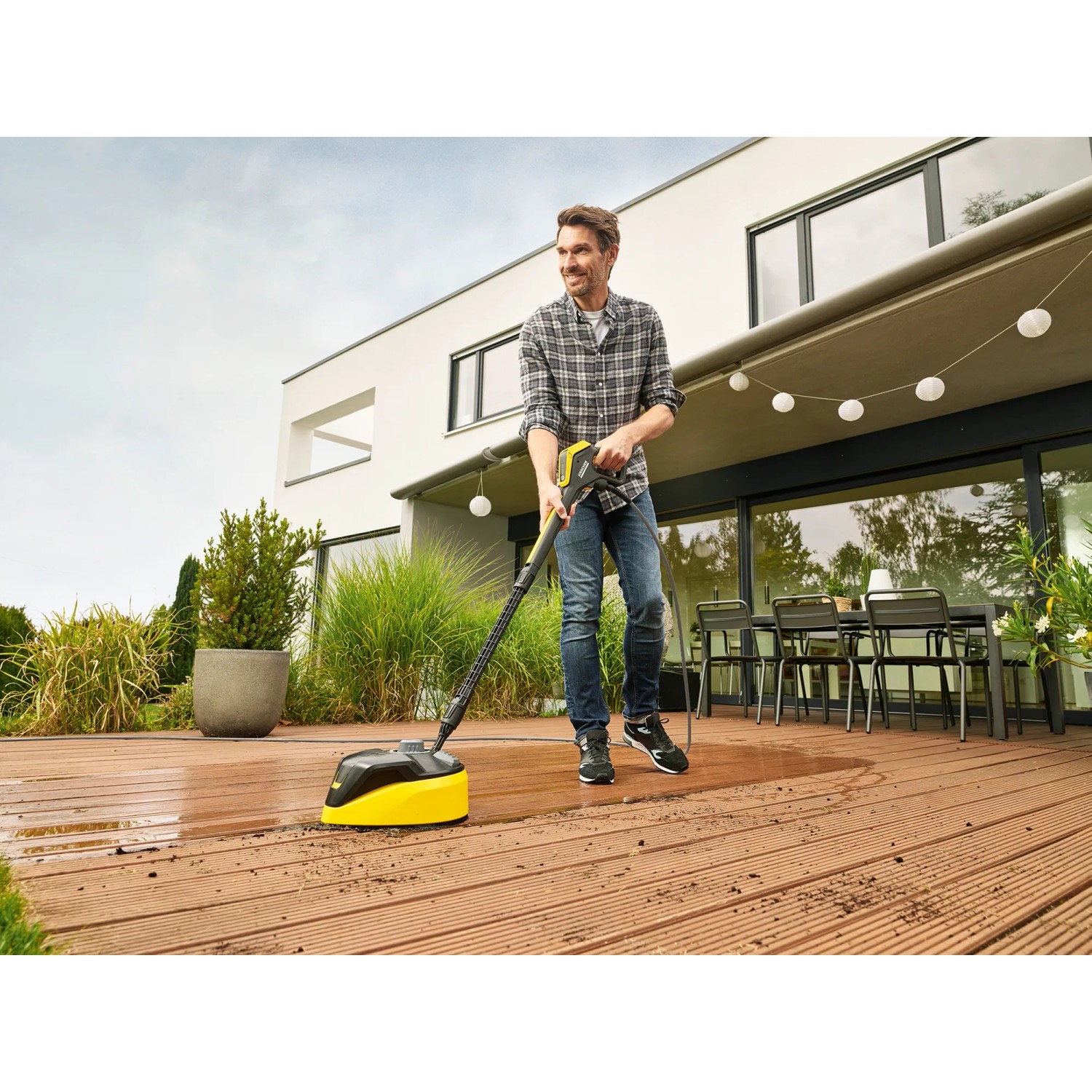 Mann reinigt Terrasse mit Kärcher K 7 Premium Smart Control Hochdruckreiniger.