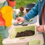 Bunte Smoby Matschküche Life mit Zubehör und Kind, das Wasser laufen lässt.
