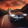 Auto mit Osram LED Night Breaker Vintage H4 Lampen auf der Straße bei Dämmerung.