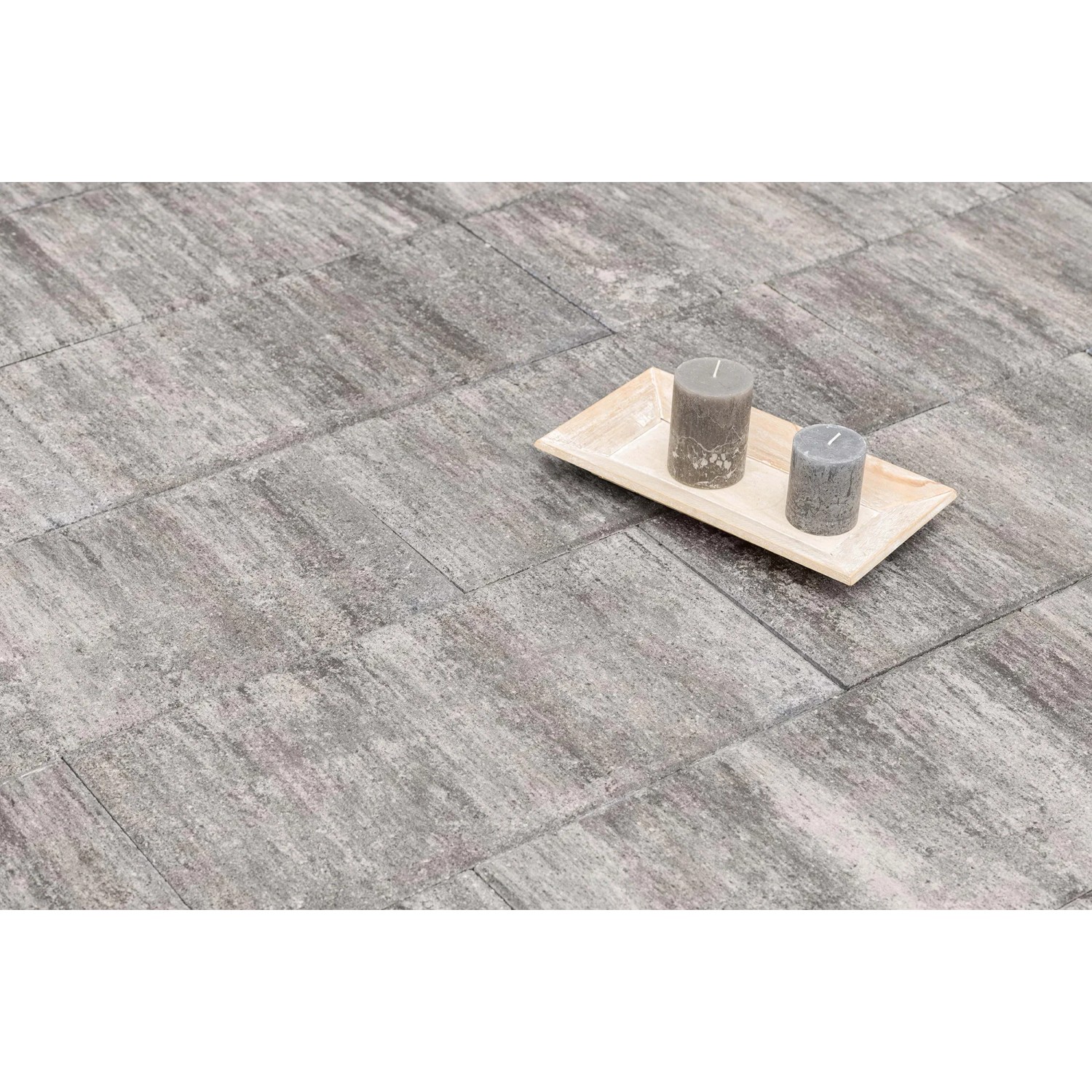 Diephaus Terrassenplatte Corso Greige 60x30, graue Steinplatten mit Farbnuancen, zwei Kerzen auf Holztablett.