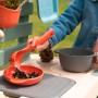 Kind spielt mit Smoby Matschküche Life: Rote Schüssel und Schöpfkelle mit Erde.
