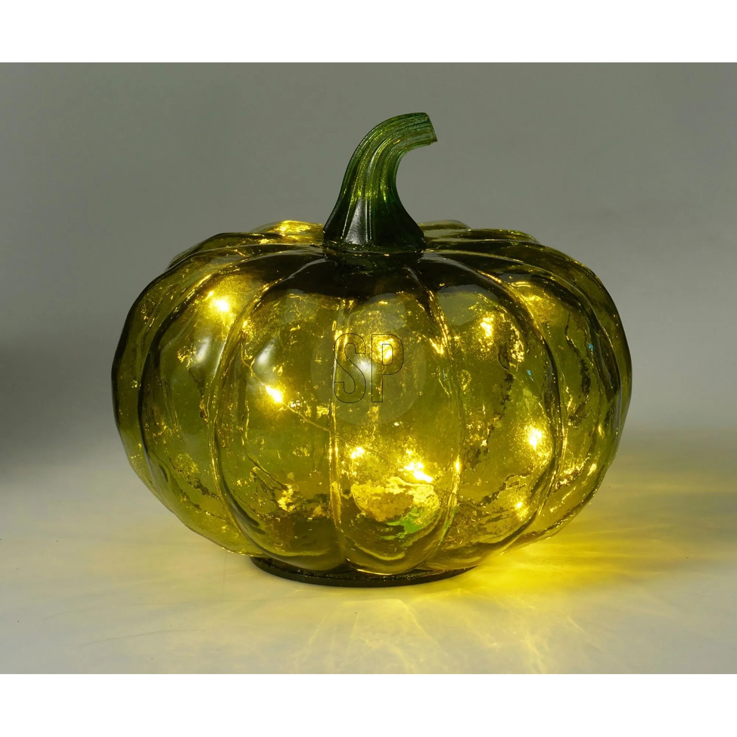 Grüne Kürbis Glaslampe mit warm leuchtenden LEDs. Dekorative Figur für festliche Herbst- und Halloween-Stimmung.