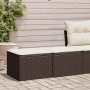 Braune 2-teilige Garten-Sofagarnitur aus Rattan mit cremefarbenen Kissen.