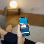 Person steuert Bosch Smart Home Wassermelder BWA-1 per Smartphone App.