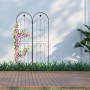 Zwei dunkelgrüne Rankgitter aus Eisen mit Rundbogen und Herz-Ornamenten, eines mit pinken Kletterblumen. Ideal für Gartengestaltung.