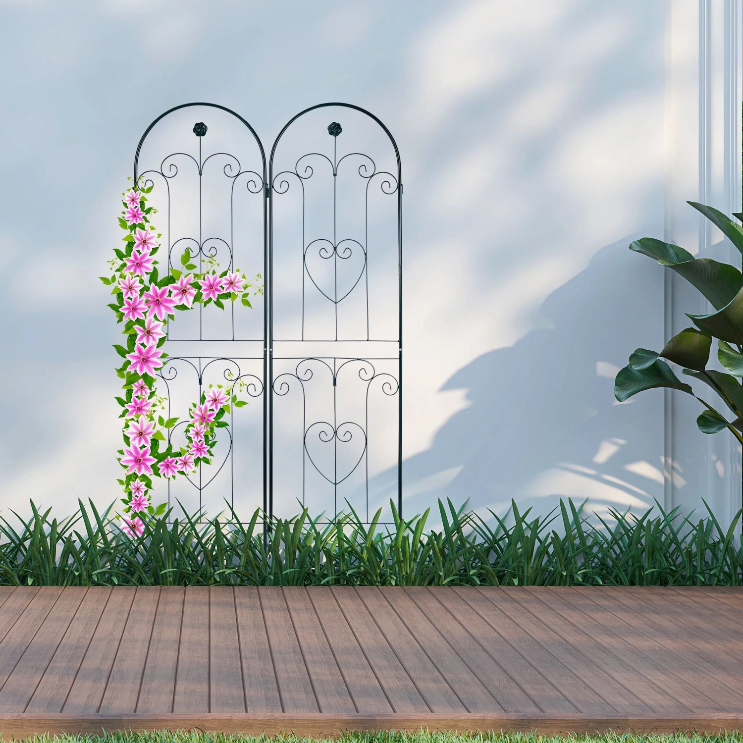 Zwei dunkelgrüne Rankgitter aus Eisen mit Rundbogen und Herz-Ornamenten, eines mit pinken Kletterblumen. Ideal für Gartengestaltung.