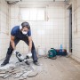 Mann arbeitet mit Bosch Hammerbohrer SDS max-4 an Fliesen im Bad.