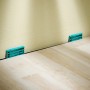 Verlege-Set: Laminat- und Designboden mit Keilen für Dehnungsfugen an der Wand.
