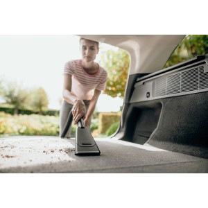 Frau saugt mit Kärcher Autodüse Kofferraum. Nass-/Trockensauger Zubehör für Auto & Haushalt.