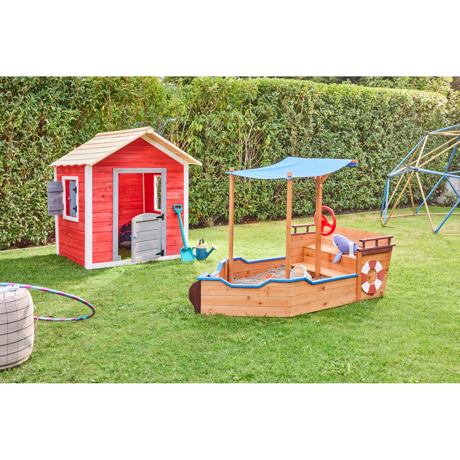 Home Deluxe Sandkasten Matschekiste in Schiffsform mit Sonnendach im Garten.