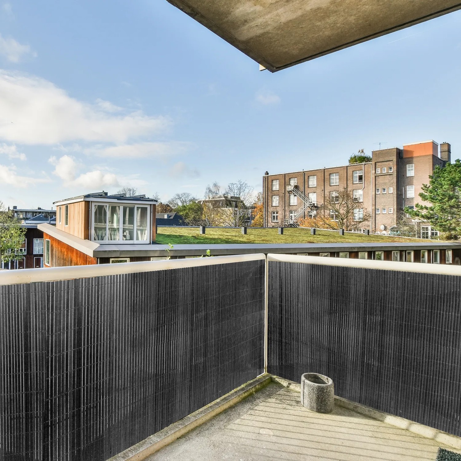 Graue PVC Sichtschutzmatte auf Balkon, schützt vor Blicken und Wind. Ideal für Garten & Terrasse.