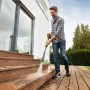 Mann reinigt Holztreppe mit Kärcher K 4 Power Control Flex Hochdruckreiniger.