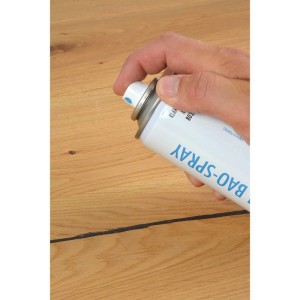 Hand sprüht Bao Klarlack 800 glänzend aus Spraydose auf Holzoberfläche. Ideal für Möbel-Ausbesserungen.