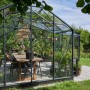 Juliana Gewächshaus Orangerie 21 in Schwarz-Anthrazit mit Tisch und Pflanzen.