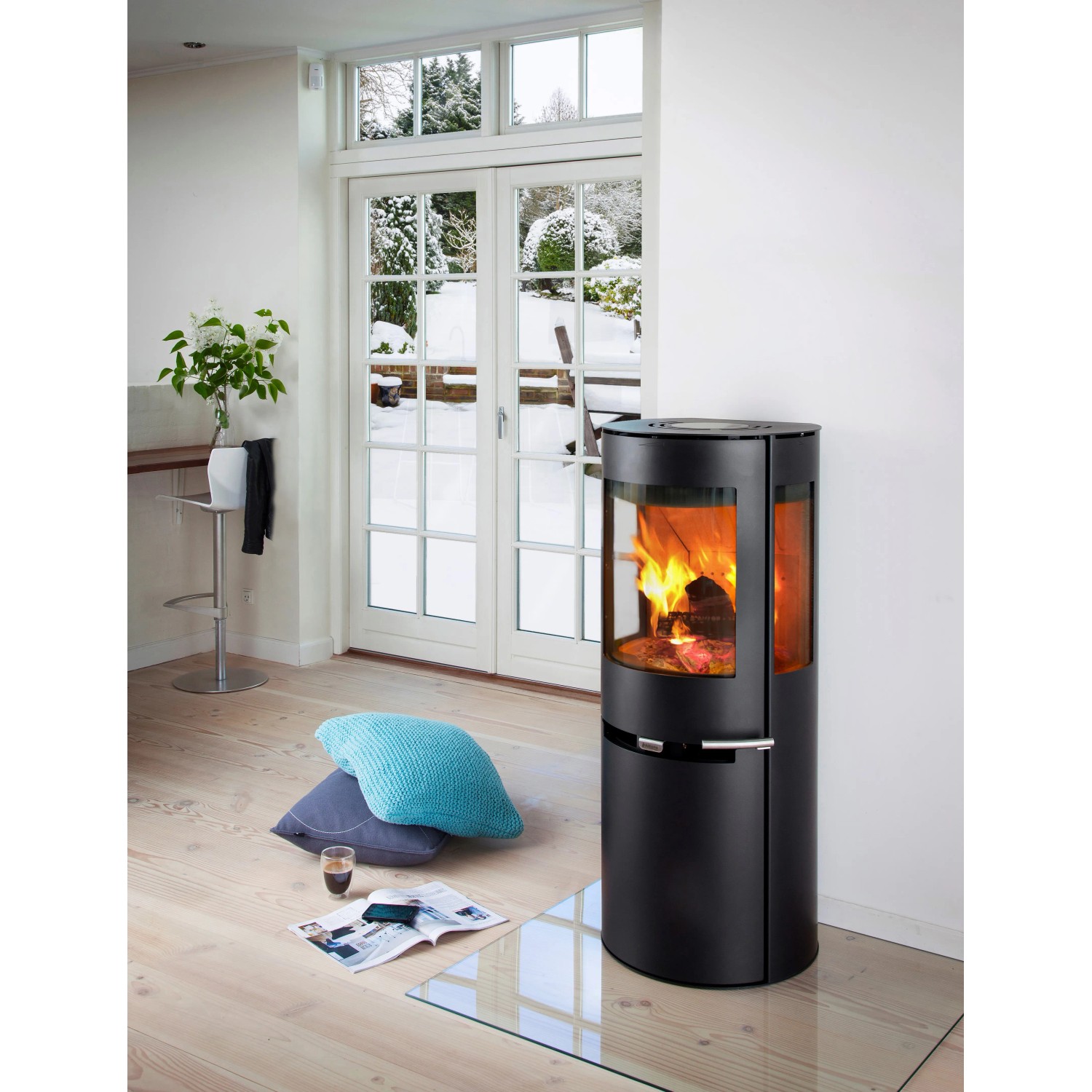 Schwarzer Aduro 9.5 Kaminofen aus Stahl mit Automatik und brennendem Holz im Wohnraum.