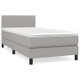 Helles Boxspringbett 90x190 cm mit Matratze und Kopfteil, Stoffbezug.