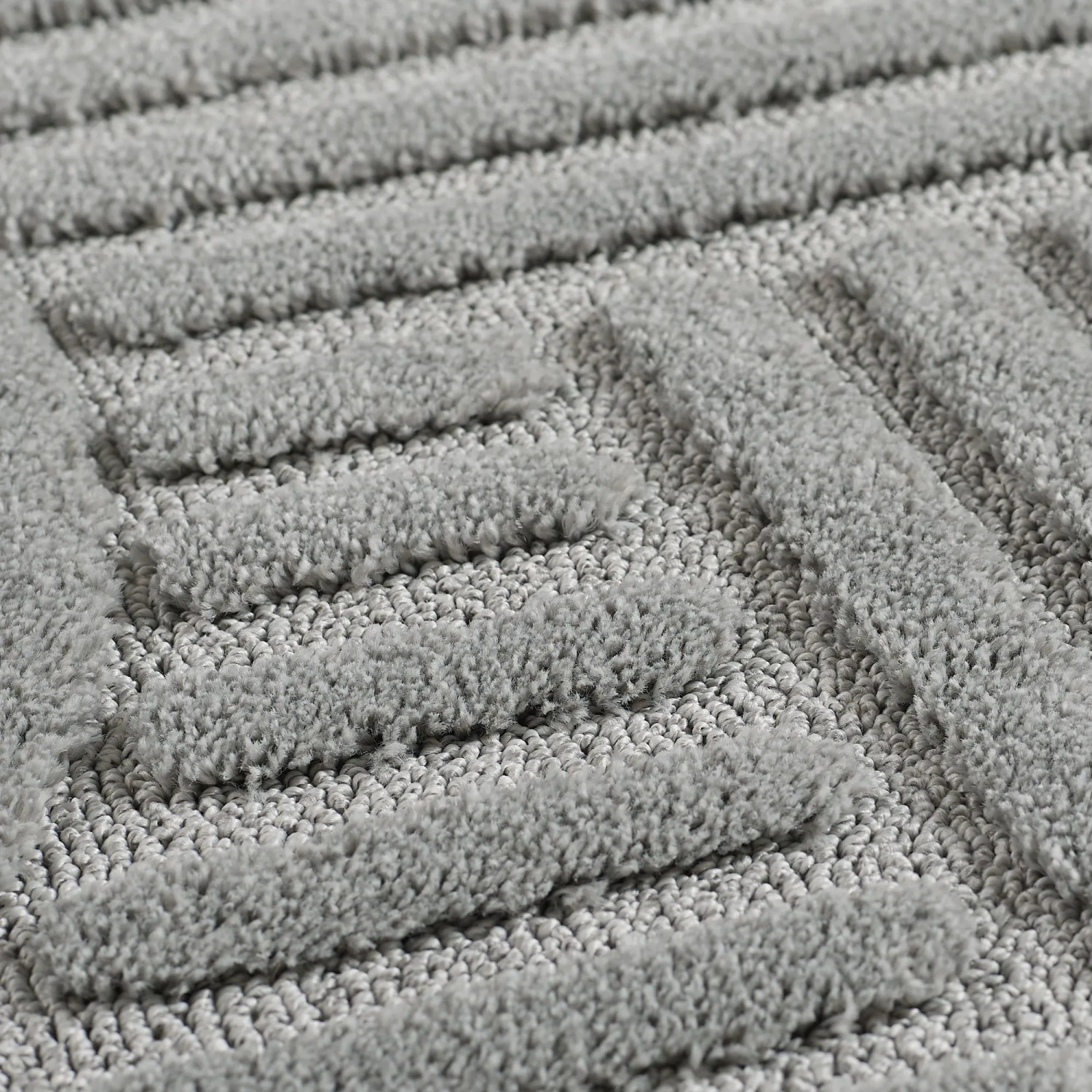 Detailansicht des silbernen Ayyildiz Kurzflorteppichs mit geometrischem 3D-Relief.