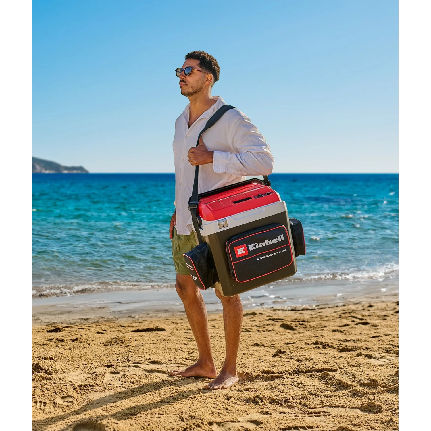 Einhell Akku-Kühlbox TE-COL 18/27 Li-Solo am Strand mit Tragegurt. Ideal für unterwegs.