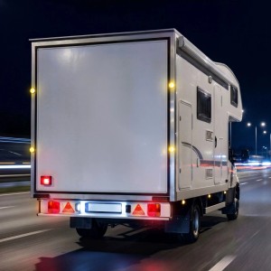 Wiltec Anhängerbeleuchtung Set mit roten Rückleuchten, Reflektoren und gelben Seitenmarkierungen am Fahrzeugheck bei Nacht.