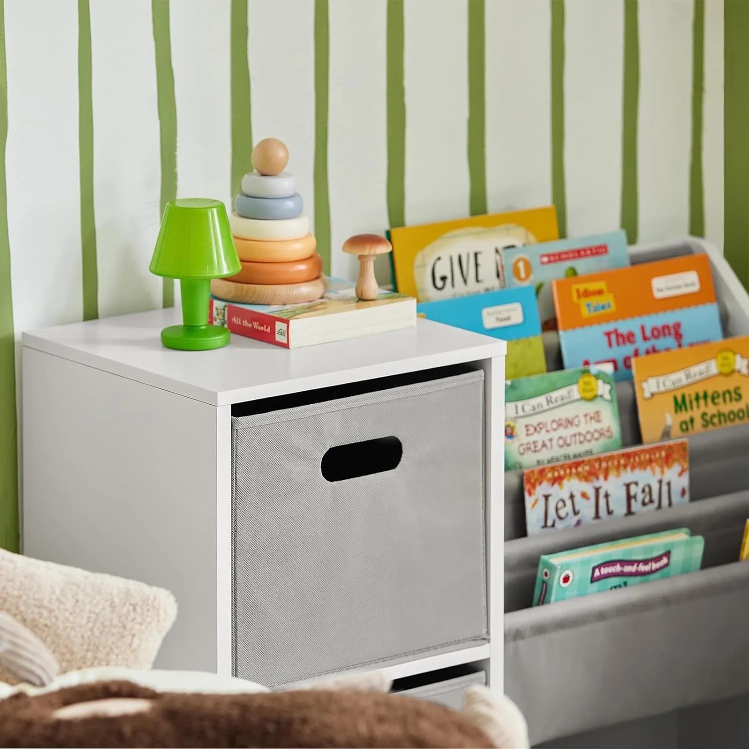 Weißes SoBuy Bücherregal mit Stoffboxen und Ablagen für Kinderbücher und Spielzeug.