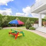 Bunter Axi Nick Picknicktisch Regenbogen mit Sonnenschirm im Garten.