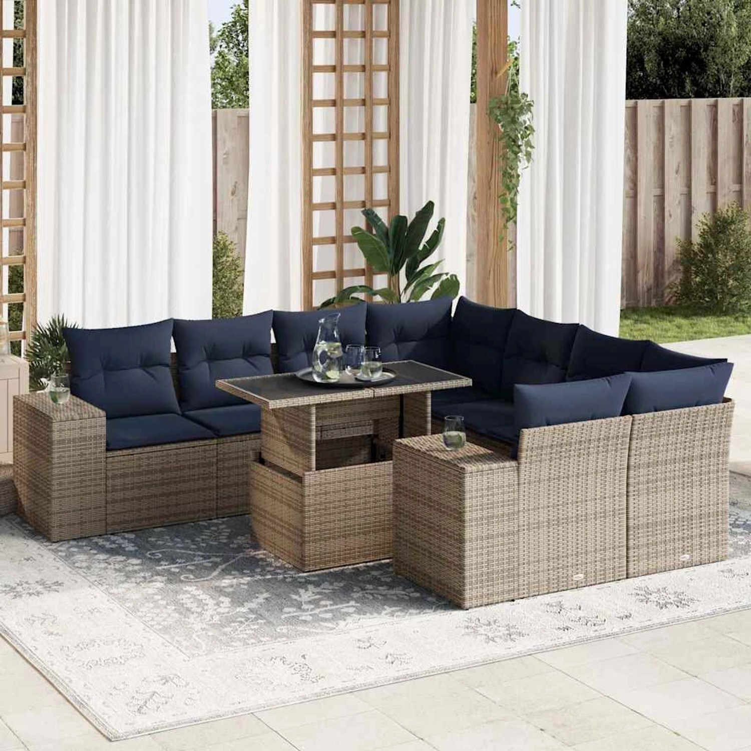 Graue 9-teilige Garten-Sofagarnitur aus Polyrattan mit Akazienholz-Tisch und blauen Kissen.