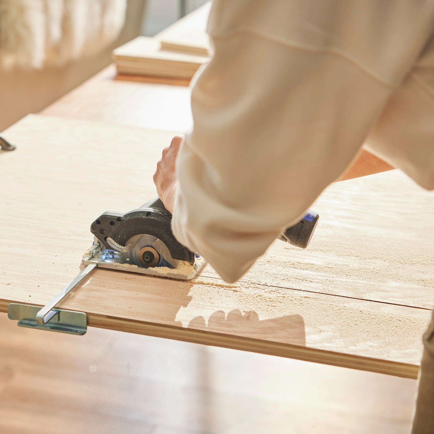 Dremel Kreissäge CS12V-S1C im Einsatz: Zuschnitt von Holzplatte mit Führungsschiene.