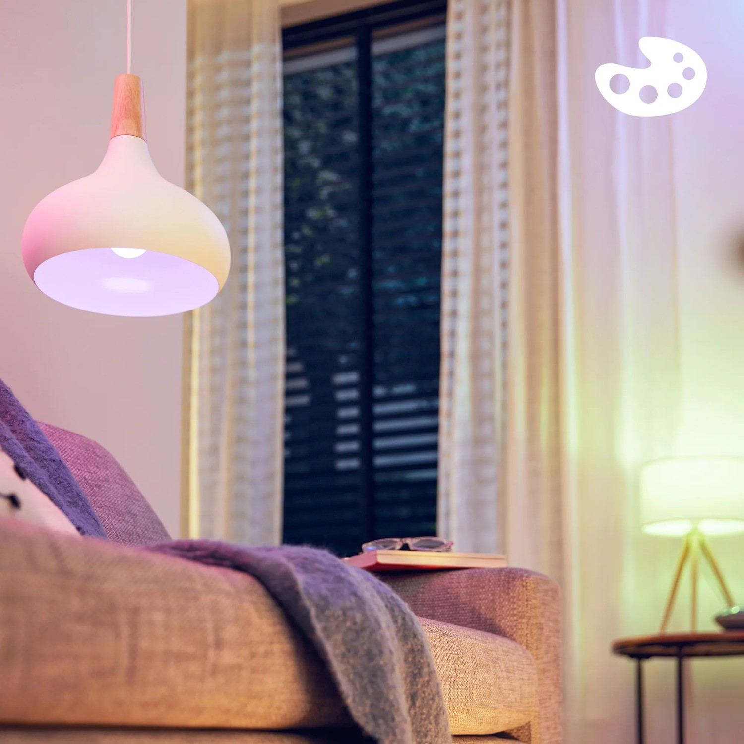 Philips WIZ E14 Kerzenlampe 3er-Set mit farbigem Licht in Wohnraum-Szene.