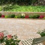 Verlegte sandsteingelbe Encanto Antik Pflastersteine im Mehrformat mit Gartenambiente.