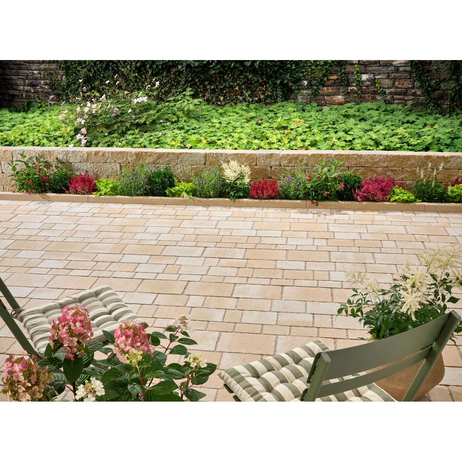 Verlegte sandsteingelbe Encanto Antik Pflastersteine im Mehrformat mit Gartenambiente.