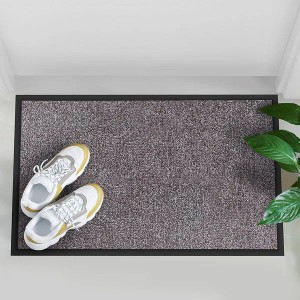 Beige-graue Karat Schmutzfangmatte Rhine 60x90 cm als Fußmatte vor einer Tür mit Schuhen.
