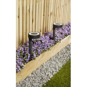 Luxform Solar-Steckleuchte Orange, 10lm, im Gartenbeet mit lila Blumen und Holzzaun im Hintergrund.