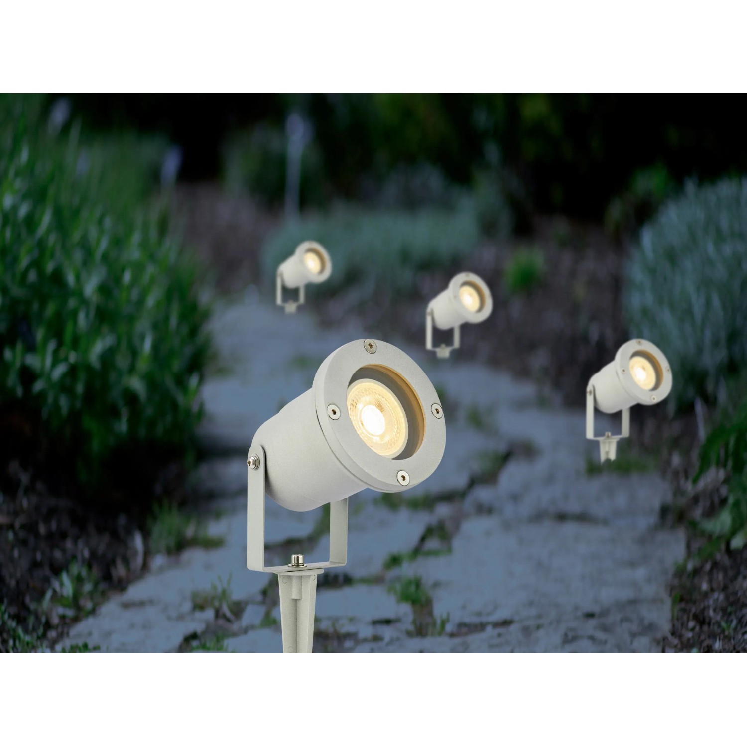 Graue LED Gartenstrahler mit GU10 Fassung beleuchten einen Gartenweg.